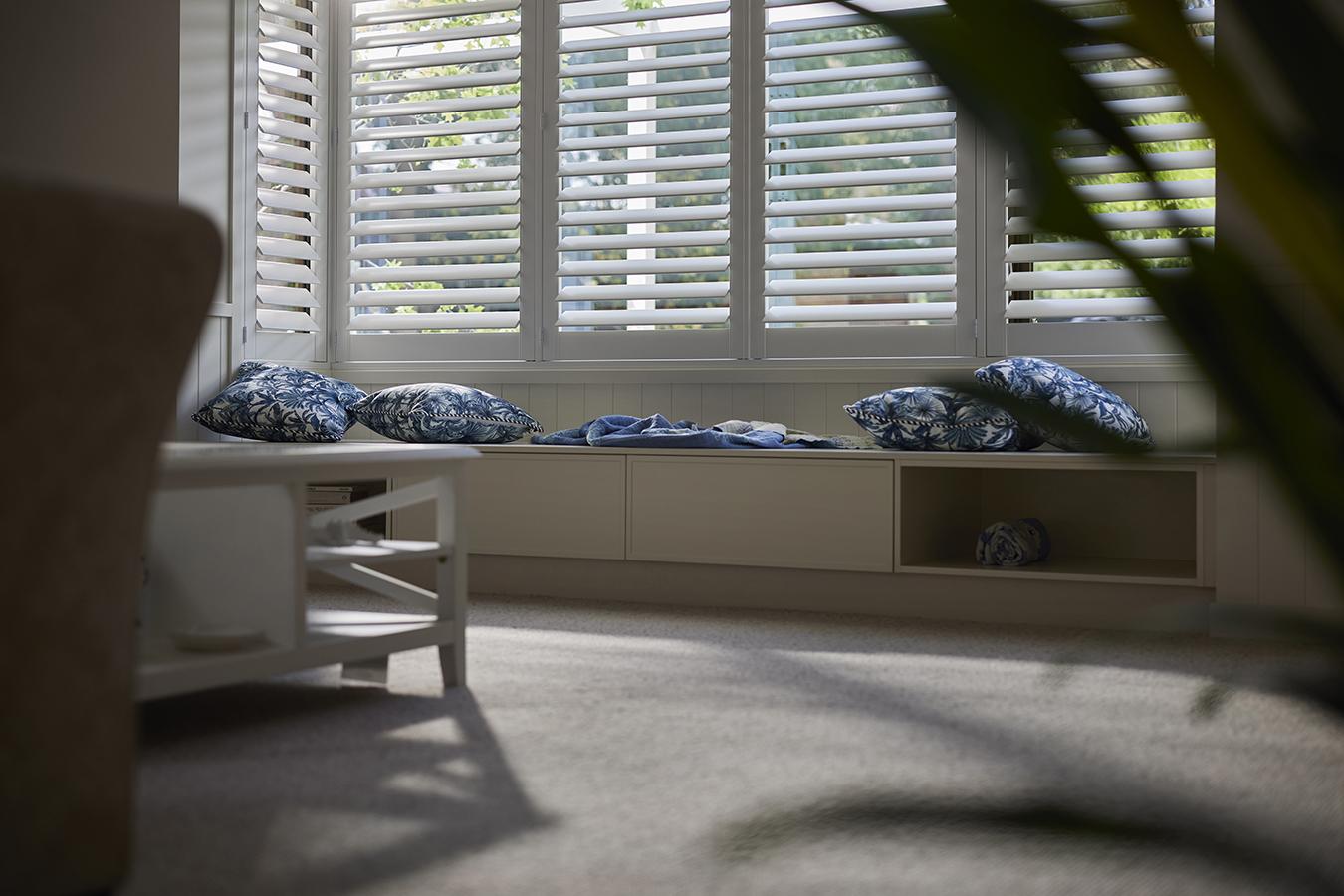 Shutter louvres closing evenly across a tall window